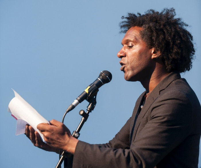 man reading from paper into microphone