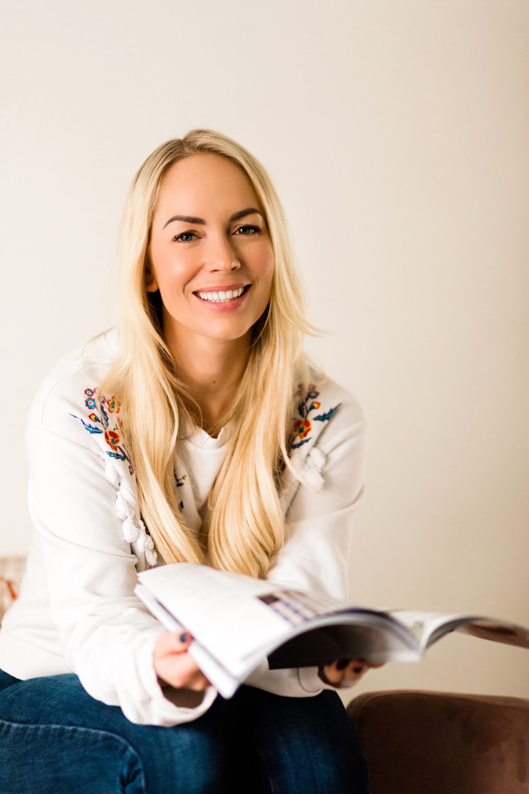 woman smiling holding open book