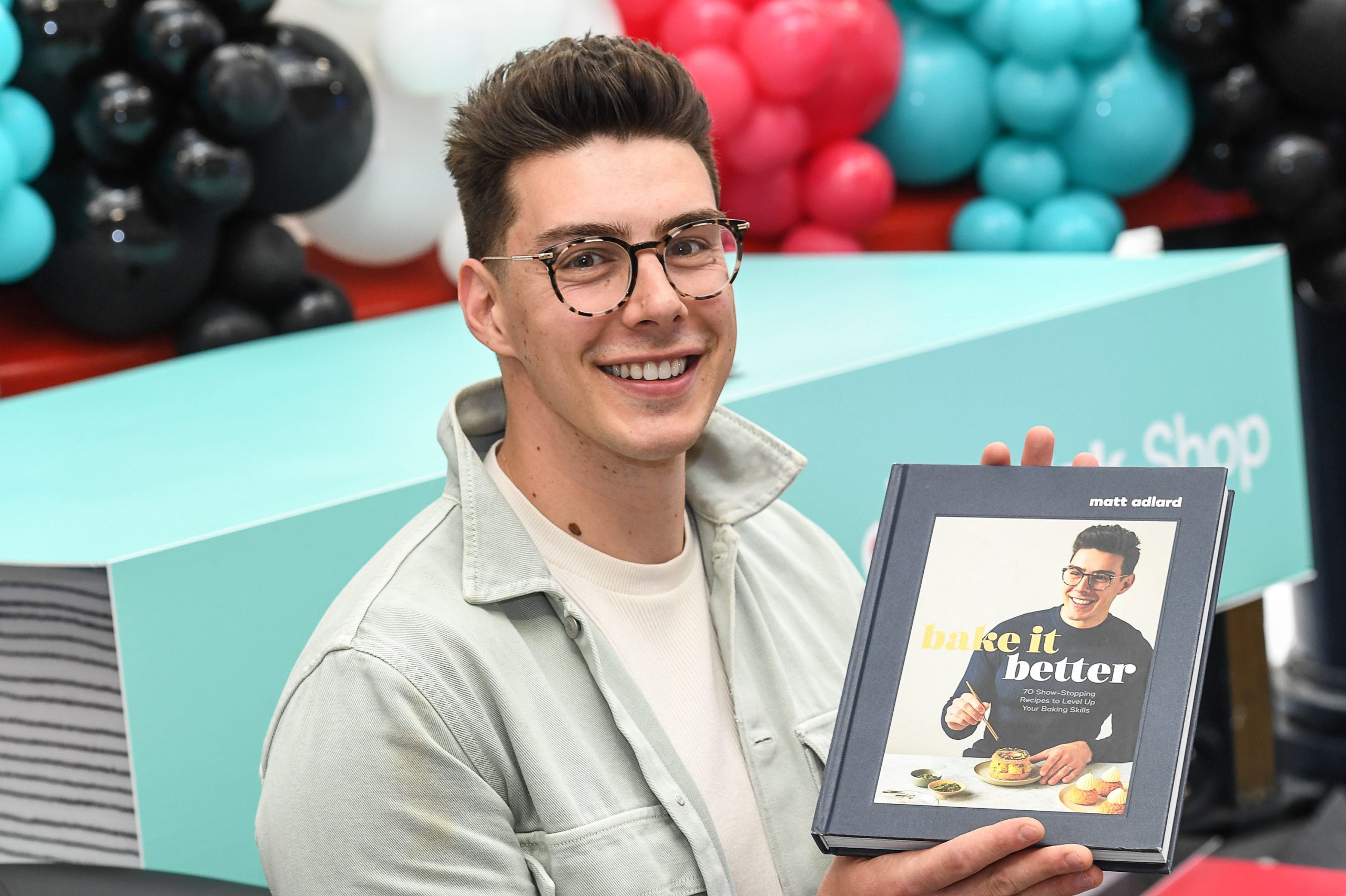 man holding book and smiling