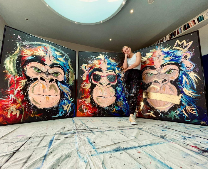 woman standing behind gorilla artwork