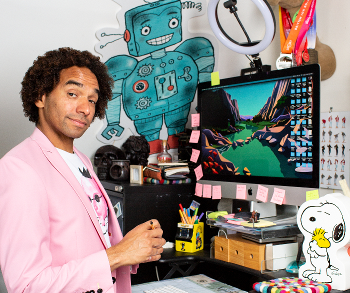 man smiling next to computer