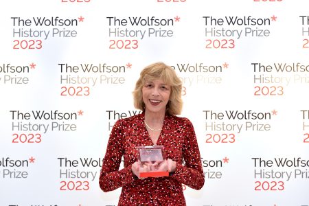 woman in red spotted dress holding prize